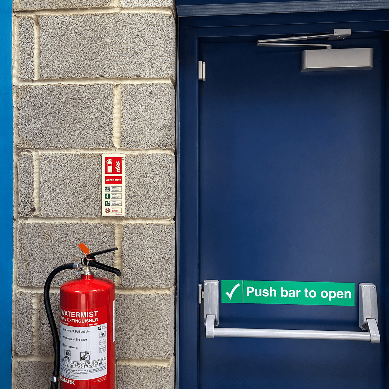 Water mist fire extinguisher installed beside a commercial fire exit