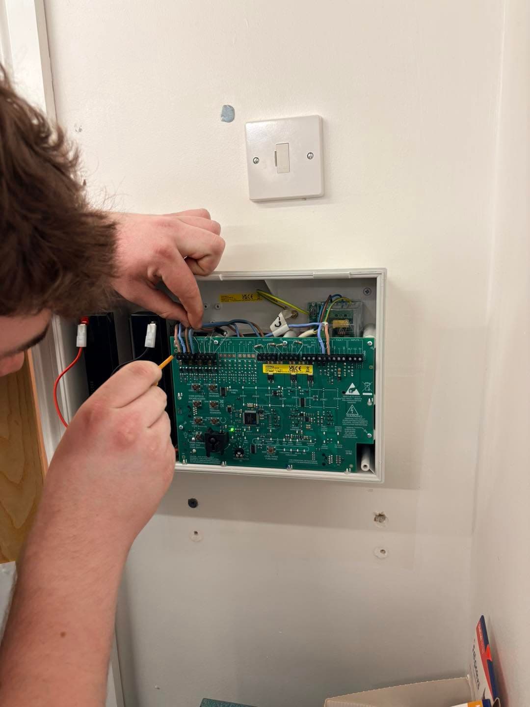 Bluebird Security engineer transferring wiring during a fire alarm panel replacement