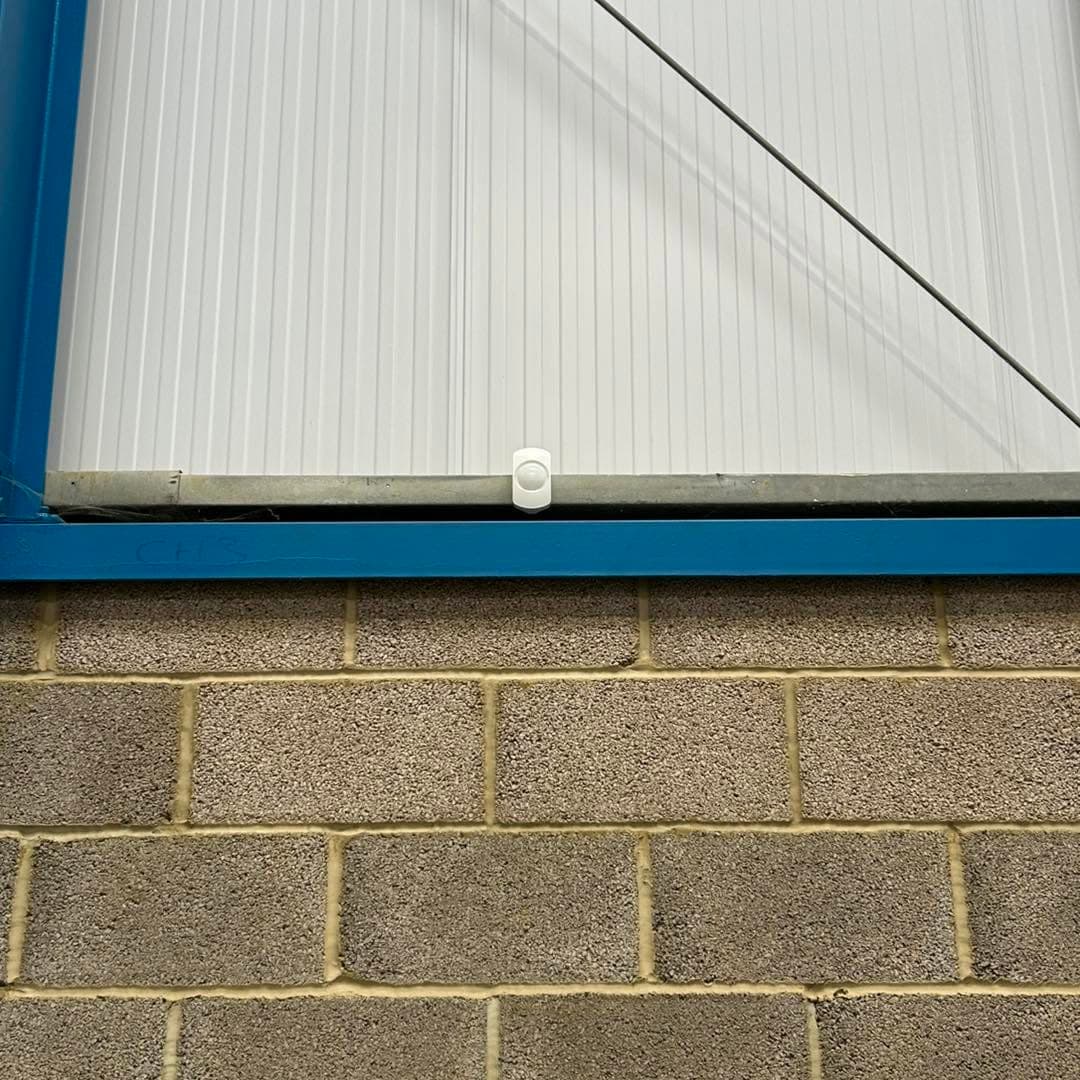 Intruder alarm detector installed above a commercial roller shutter
