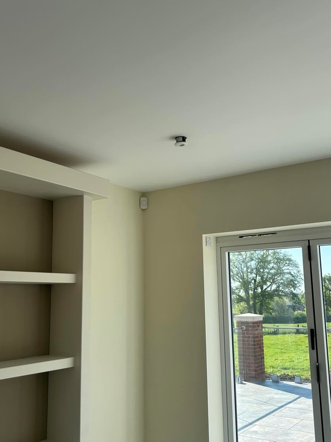 Texecom Premier Elite alarm keypad installed beside a heating controller