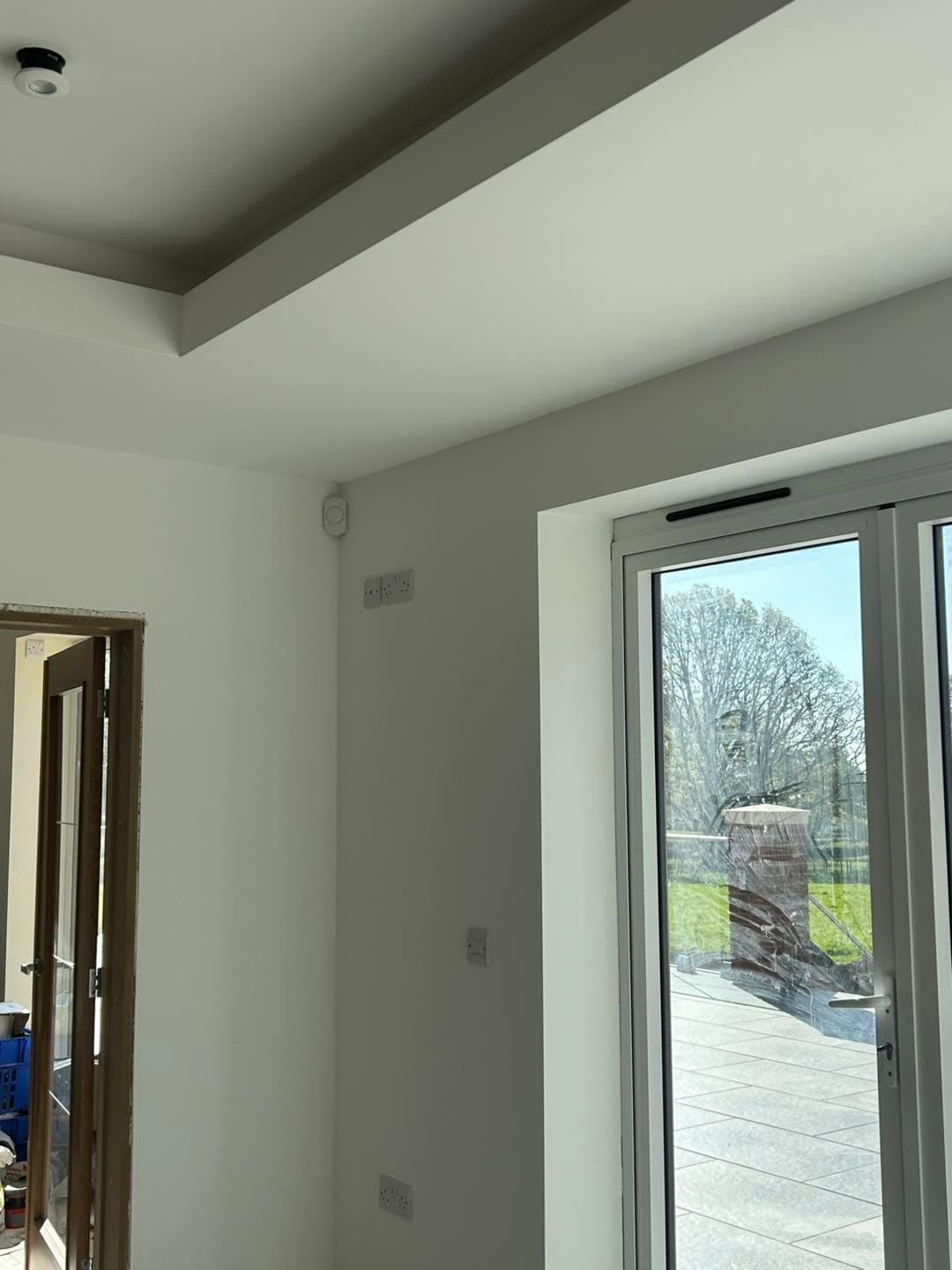 Residential alarm detector installed near a patio door
