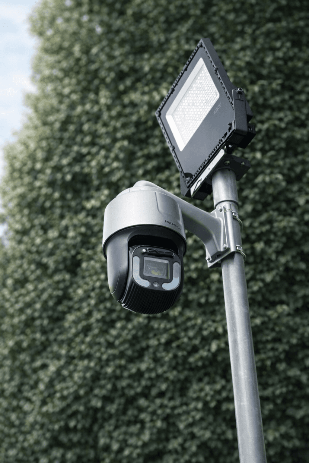 Outdoor PTZ CCTV camera mounted on a pole beside security lighting